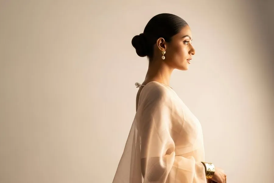 rich indian woman wearing beige saree